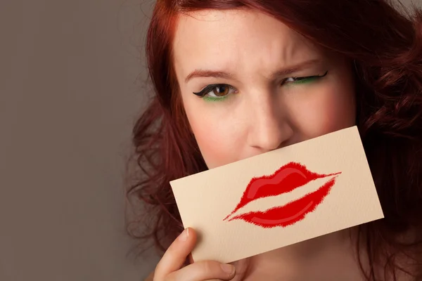 Glücklich hübsche Frau hält Karte mit Kuss Lippenstift Marke — Stockfoto