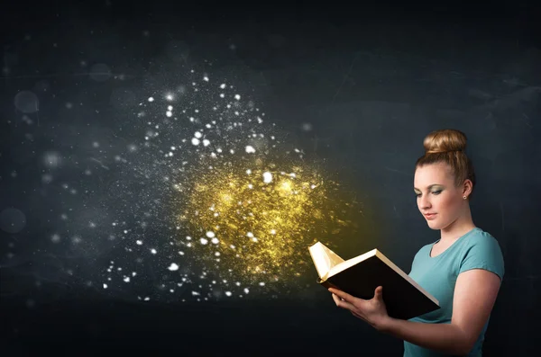 Jovem senhora lendo um livro mágico — Fotografia de Stock