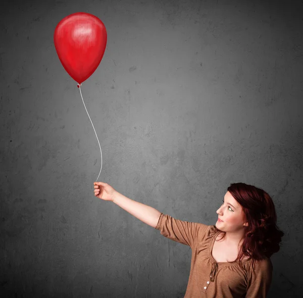 Kobieta trzymająca czerwony balon — Zdjęcie stockowe