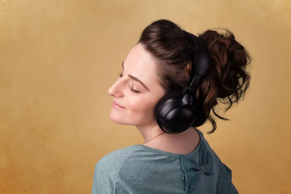 Mujer joven con auriculares escuchando música con espacio para copiar — Foto de Stock