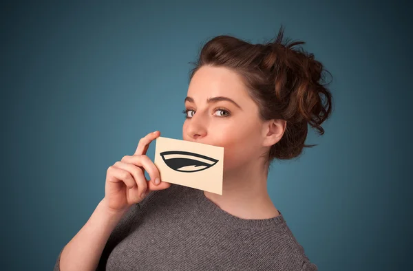 Pretty young girl holding white card with smile drawing — Stock Photo, Image