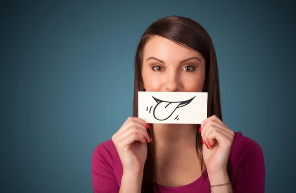 Pretty young girl holding white card with smile drawing — Stock Photo, Image