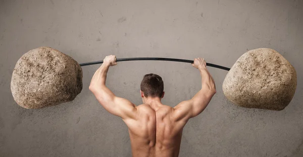 Muscular man lifting large rock stone weights — Stock Photo, Image