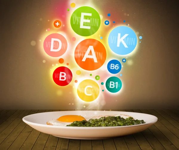 Food plate with delicious meal and healthy vitamin symbols — Stock Photo, Image