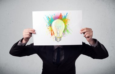 boya sıçraması ve lightbul ile bir karton tutan işadamı