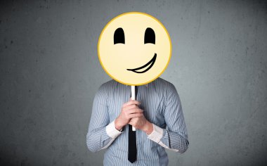 Elinde gülen surat ifadesi olan bir iş adamı.