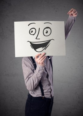 empresario sosteniendo una cartulina con cara sonriente en él en frente 