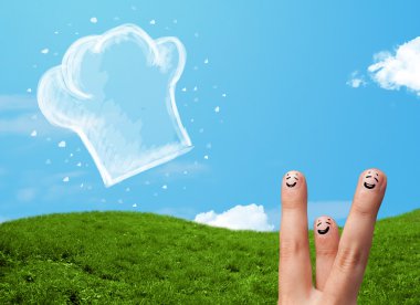 Mutlu gülen yüzlü parmaklar aşçı şapkasının resmine bakıyor.