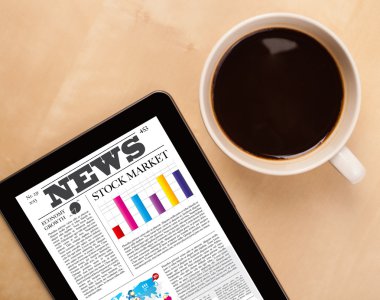 Tablet bilgisayarı haberleri ekranda bir fincan kahveyle sunar.