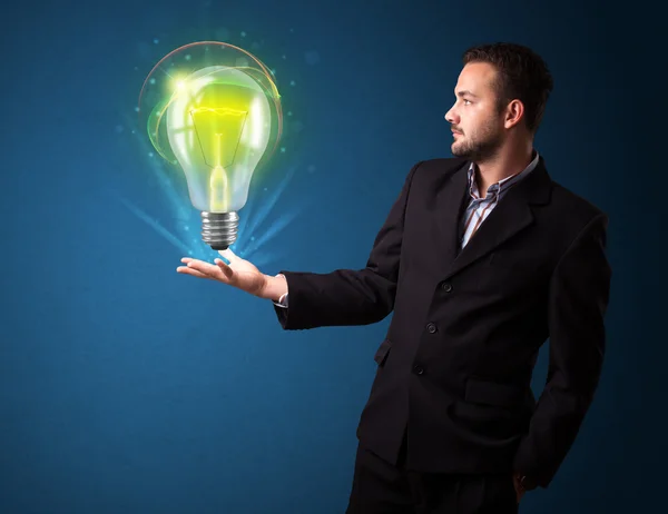 Glowing lightbulb in the hand of a businessman — Stock Photo, Image