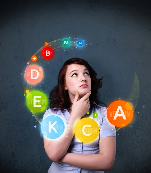 Young woman thinking with vitamins circulation around her head — Stock Photo, Image