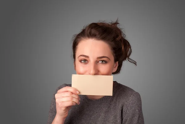 Linda chica sosteniendo la tarjeta blanca en frente de sus labios con spac copia — Foto de Stock