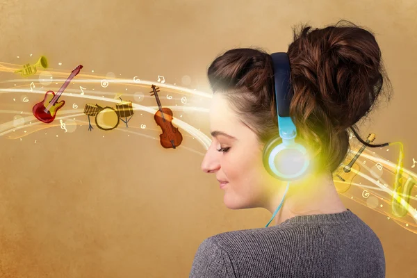 Ung kvinna med hörlurar lyssnar på musik — Stockfoto