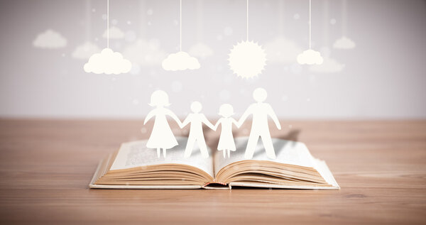 Cardboard figures of the family on opened book — Stock Photo, Image