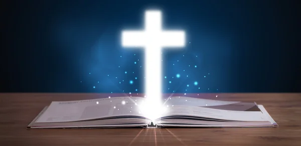 Open holy bible with glowing cross in the middle — Stock Photo, Image