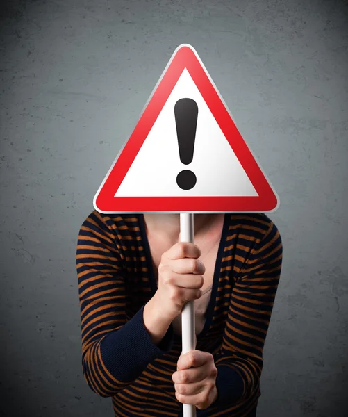 Young woman holding an exclamation road sign — Stock Photo, Image