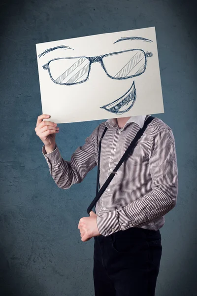 Бизнесмен держит газету с улыбающимся лицом перед носом — стоковое фото
