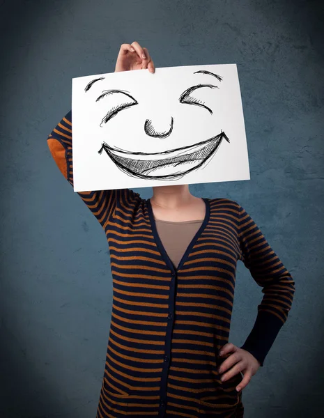 Woman with drawed smiley face on a paper in front of her head — Stock Photo, Image