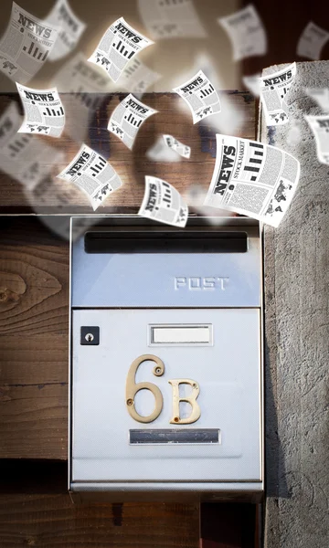 Post box with daily newspapers flying — Stock Photo, Image