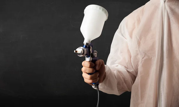 Pintor trabalha com pistola de aerógrafo e espaço livre vazio — Fotografia de Stock