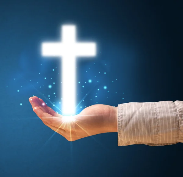 Glowing cross in the hand of a woman — Stock Photo, Image