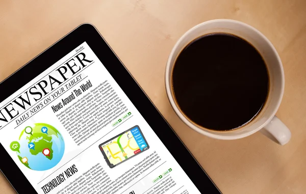 Tablet pc shows news on screen with a cup of coffee on a desk — Stock Photo, Image