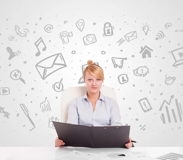 Business woman sitting at table with hand drawn media icons — Stock Photo, Image