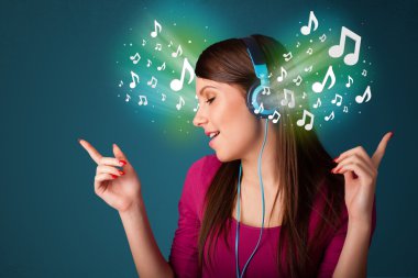 Kulaklıklı genç bir kadın müzik dinliyor.