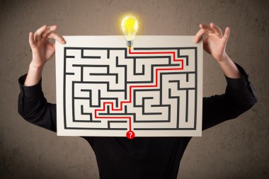 bir labirent ile bir kağıt üzerinde h tutan işadamı