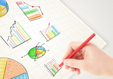 İşadamı kağıda renkli grafikler ve simgeler çiziyor