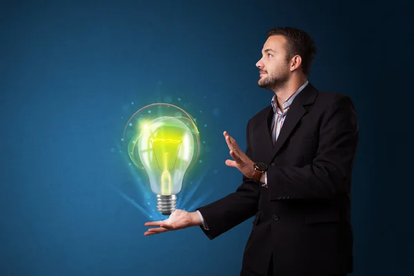 Glowing lightbulb in the hand of a businessman — Stock Photo, Image