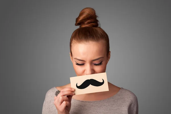 Glückliches nettes Mädchen hält Papier mit Schnurrbart Zeichnung — Stockfoto