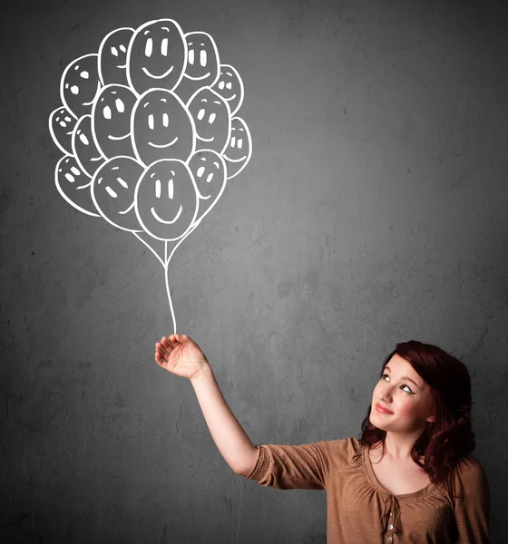 Woman holding a bunch of smiling balloons — Stock Photo, Image