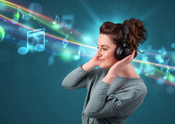 Kulaklıkla müzik dinleyen genç bir kadın.