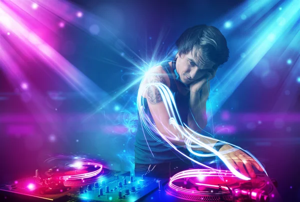 Energiska dj blandande musik med kraftfulla ljuseffekter — Stockfoto