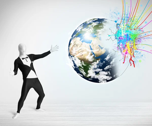 Funny man in body suit looking at colorful splatter earth — Stock Photo, Image