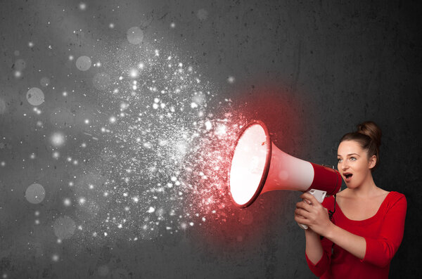 Женщина кричит в мегафон и исследует светящиеся частицы энергии
