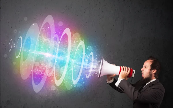 L'homme crie dans un haut-parleur et un faisceau d'énergie coloré sort — Photo