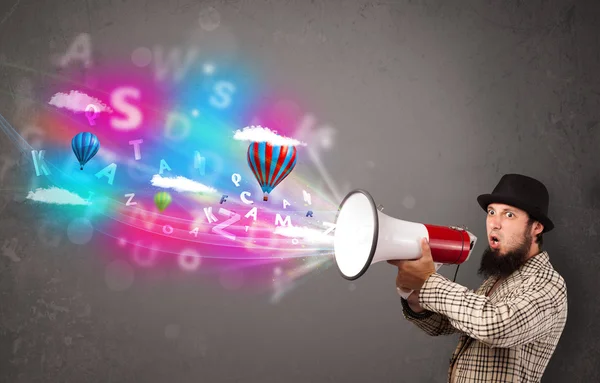 Man shouting into megaphone and abstract text and balloons come — Stock Photo, Image