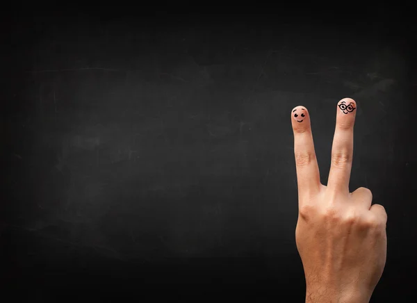 Happy smiley fingers looking at empty black chalboard — Stock Photo, Image