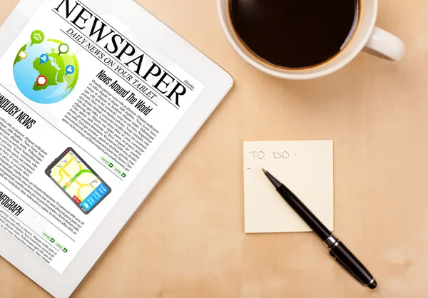 Tablet pc shows news on screen with a cup of coffee on a desk — Stock Photo, Image