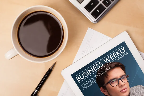 Tablet pc showing magazine on screen with a cup of coffee on a d — Stock Photo, Image