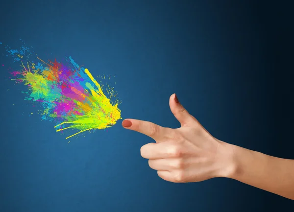 Colorful splashes are coming out of gun shaped hands — Stock Photo, Image