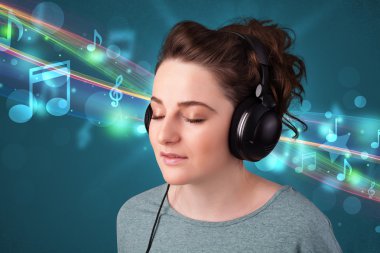 Kulaklıkla müzik dinleyen genç bir kadın.
