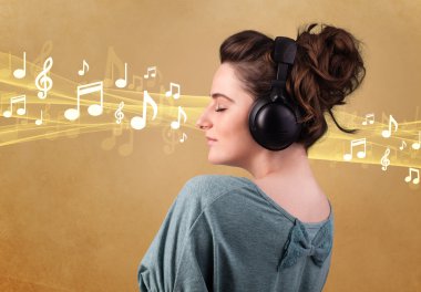 Kulaklıklı genç bir kadın müzik dinliyor.