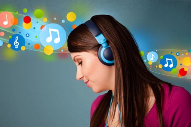 Kulaklıkla müzik dinleyen genç bir kadın. 