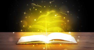 Altından parlak uçan kağıt sayfaları olan açık bir kitap