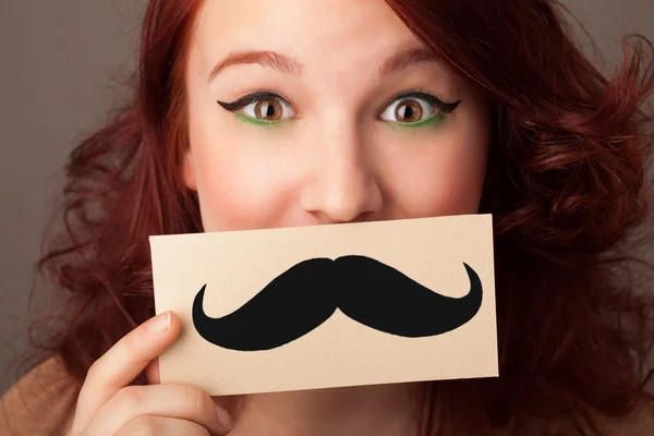 Feliz linda chica sosteniendo papel con bigote dibujo —  Fotos de Stock