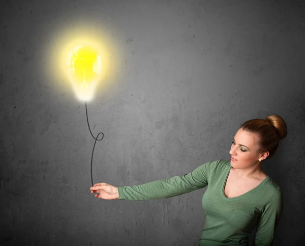 Woman holding a lightbulb balloon — Stock Photo, Image