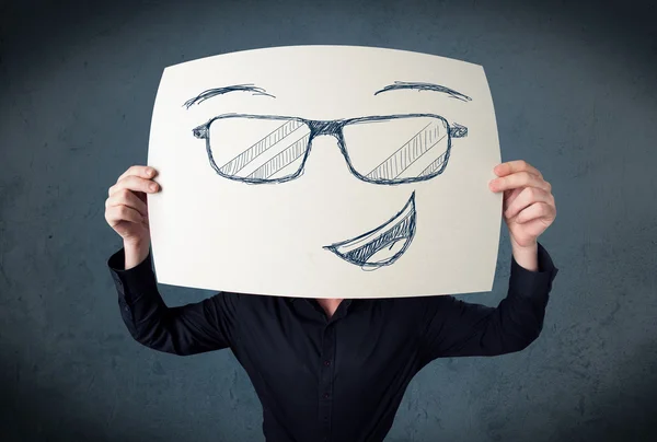 Geschäftsmann hält ein Papier mit Smiley-Gesicht vor seinen Kopf — Stockfoto